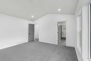 Unfurnished bedroom featuring lofted ceiling, carpet floors, a spacious closet, and recessed lighting