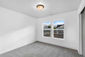 Unfurnished room featuring light carpet and baseboards