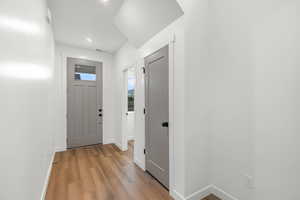 Foyer with light wood finished floors and recessed lighting