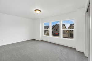 Empty room featuring light carpet