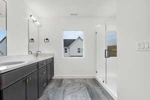 Full bath with double vanity and a stall shower