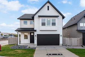 View of front of house with a shingled roof, a garage, covered porch, and driveway