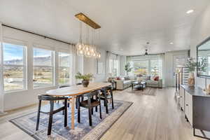 Dining space featuring light wood-type flooring, recessed lighting, a mountain view, a chandelier, and ceiling fan