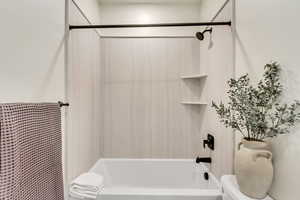 Bathroom featuring shower / tub combo with curtain and toilet