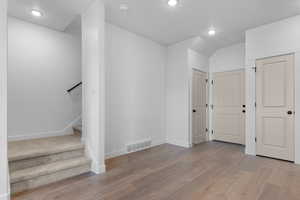 Basement featuring recessed lighting, light wood-style flooring, and stairway