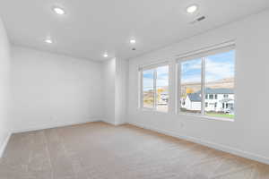 Spare room with light carpet, recessed lighting, and a residential view