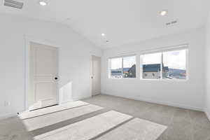 Spare room with light carpet, vaulted ceiling, and recessed lighting