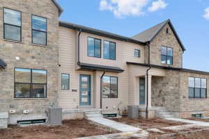 View of front of property with stone siding and a shingled roof