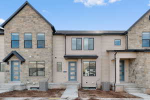 View of front of property with stone siding and a shingled roof