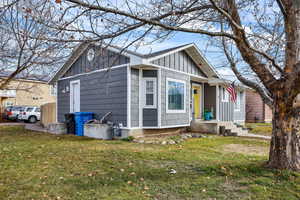 View of front of house with board and batten siding and a front lawn
