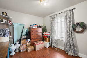 Bedroom with dark wood-type flooring and baseboards