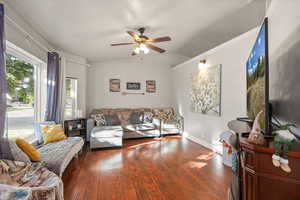 Living area with hardwood / wood-style floors, ceiling fan, and lofted ceiling