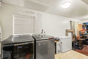 Laundry room featuring a textured ceiling and washer and dryer