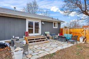 Back of property featuring a patio, roof with shingles, and an outdoor living space with a fire pit