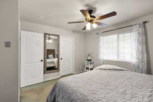 Bedroom with light carpet and a ceiling fan