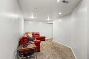 Living area featuring light colored carpet and baseboards