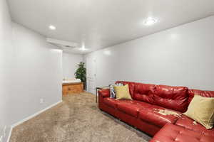 Carpeted living room featuring baseboards and a textured ceiling