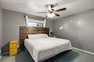 Carpeted bedroom with baseboards and a ceiling fan