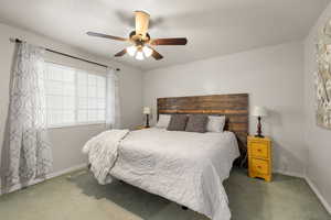 Bedroom with ceiling fan and light colored carpet