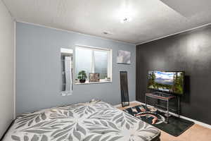 Carpeted bedroom featuring a textured ceiling