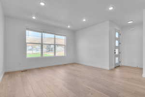 Unfurnished living room featuring light wood-type flooring and recessed lighting