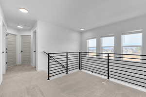 Spare room featuring light colored carpet and recessed lighting