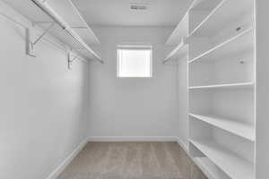 Walk in closet featuring light carpet