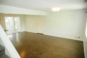 Spare room with dark wood finished floors and baseboards