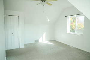 Master bedroom with lofted ceiling, carpet floors, and ceiling fan