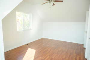 Bonus room featuring vaulted ceiling, dark wood-style floors, and ceiling fan