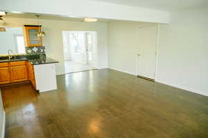Kitchen featuring glass insert cabinets, tasteful backsplash, healthy amount of natural light, and dark wood finished floors
