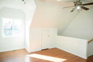 Additional living space featuring lofted ceiling, wood finished floors, and ceiling fan