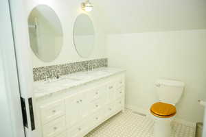 Master bathroom with double vanity, backsplash, and light tile patterned flooring