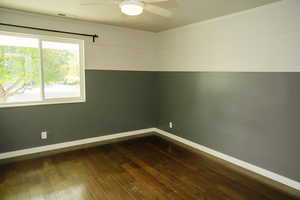 Unfurnished room featuring dark wood finished floors and a ceiling fan