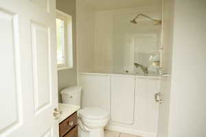 Full bathroom with tile patterned floors, vanity, and a Kohler walk in bathtub/shower combination