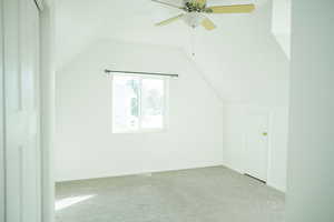Master bedroom with lofted ceiling, carpet flooring, and ceiling fan