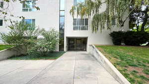Property entrance with stucco siding and a lawn