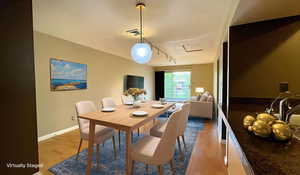 Virtually Staged - Dining area with light wood finished floors, attic access, and track lighting