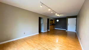 Spare room with rail lighting and light wood-style flooring