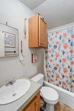 Full bath featuring a textured ceiling, vanity, and shower / bathtub combination with curtain