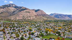 Aerial view of property and surrounding area with nearby suburban area and a mountainous background