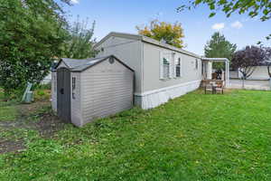 View of property exterior featuring a storage shed and a lawn