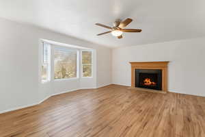 Living room featuring a fireplace, light wood finished floors and large bay window