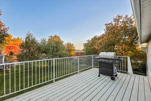 Wooden deck with area for grilling and a yard