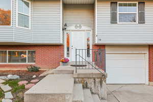 Property entrance with brick siding and an attached garage