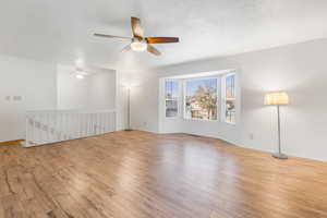 Spacious Living room featuring hardwood \flooring, ceiling fan, and large bay window