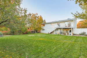 Rear view of house with stairs, a fenced backyard, and a patio