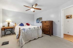 Bedroom with ceiling fan and light carpet