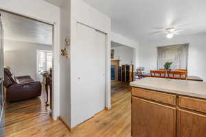 Kitchen featuring light countertops, brown cabinets, light wood-style floors, a textured ceiling, and a fireplace