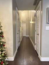 Hall featuring baseboards and dark wood-style floors